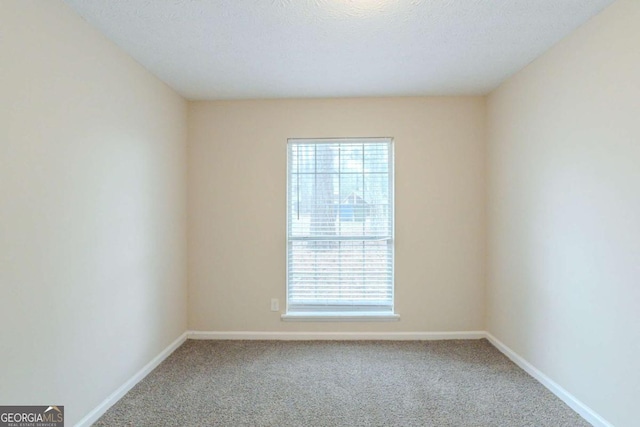 carpeted spare room with a textured ceiling