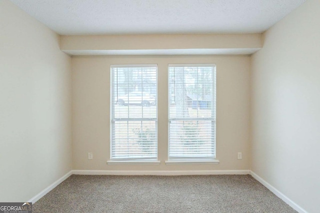 carpeted empty room featuring a textured ceiling