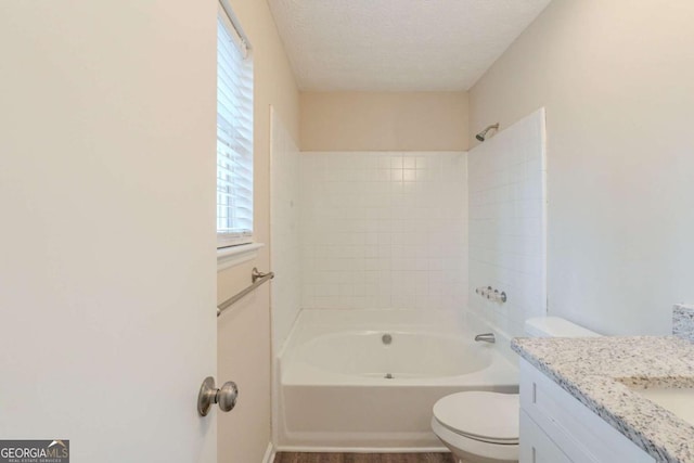 full bathroom with vanity, a textured ceiling, shower / washtub combination, and toilet