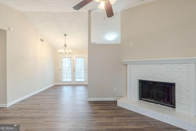 unfurnished living room with lofted ceiling, ceiling fan, hardwood / wood-style floors, a textured ceiling, and a brick fireplace