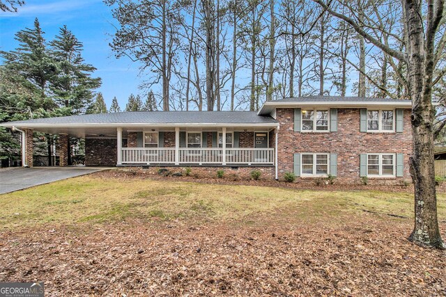 split level home with a carport, covered porch, and a front lawn