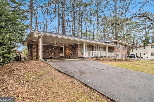 ranch-style house featuring a carport, covered porch, and a front lawn