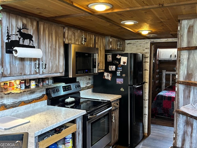 kitchen with wood ceiling, stainless steel appliances, wooden walls, and hardwood / wood-style floors