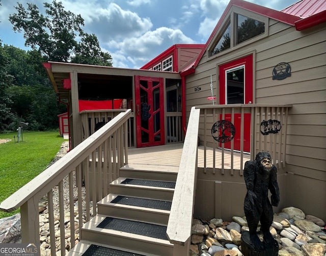 property entrance with a wooden deck and a yard