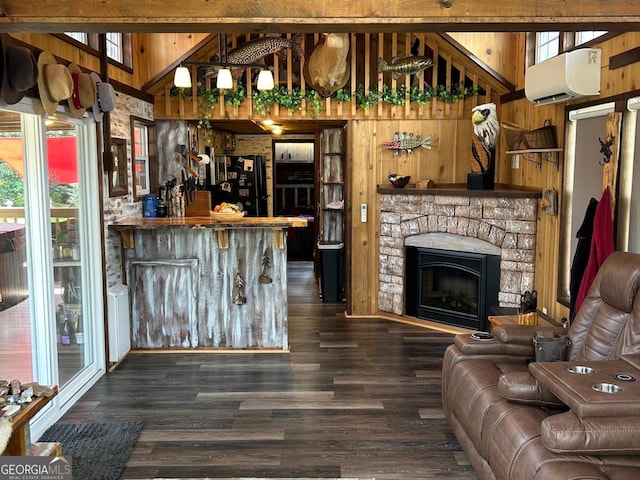 bar with an AC wall unit, a healthy amount of sunlight, black refrigerator, and wood walls