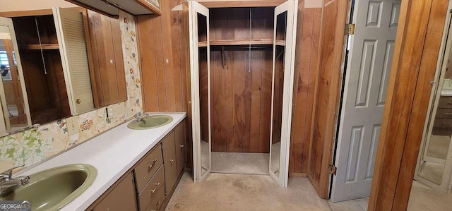 bathroom featuring vanity and wood walls