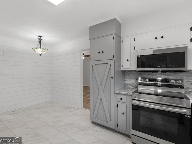 kitchen featuring white cabinetry, stainless steel appliances, light stone countertops, decorative backsplash, and decorative light fixtures