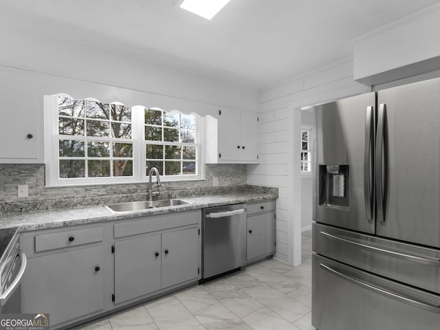 kitchen featuring gray cabinets, appliances with stainless steel finishes, sink, and decorative backsplash