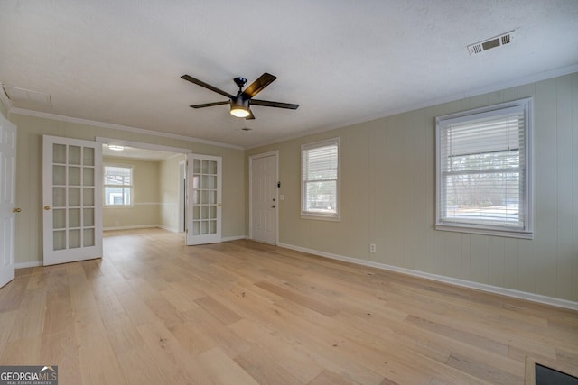 spare room with ornamental molding, french doors, ceiling fan, and light wood-type flooring