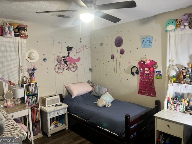 bedroom featuring ceiling fan, dark hardwood / wood-style floors, and a textured ceiling