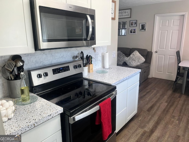 kitchen with stainless steel appliances, dark hardwood / wood-style floors, decorative backsplash, and white cabinets