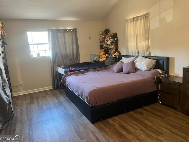 bedroom featuring lofted ceiling and dark hardwood / wood-style floors