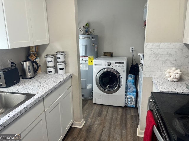 washroom with dark hardwood / wood-style floors, washer / dryer, sink, and water heater