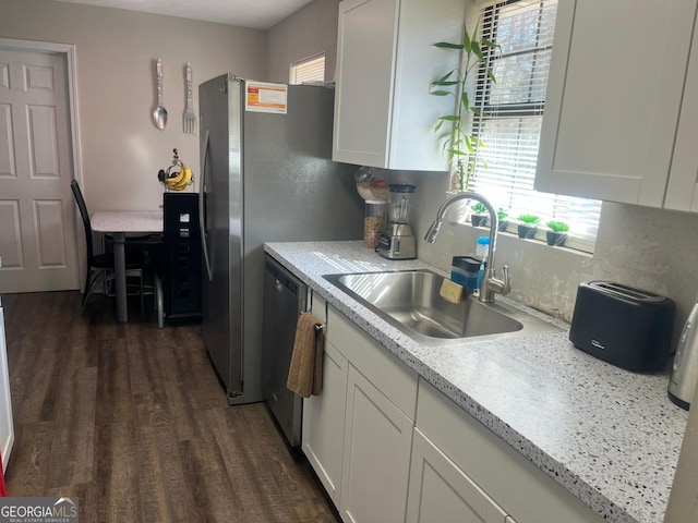 kitchen with dark wood-type flooring, sink, stainless steel appliances, light stone countertops, and white cabinets