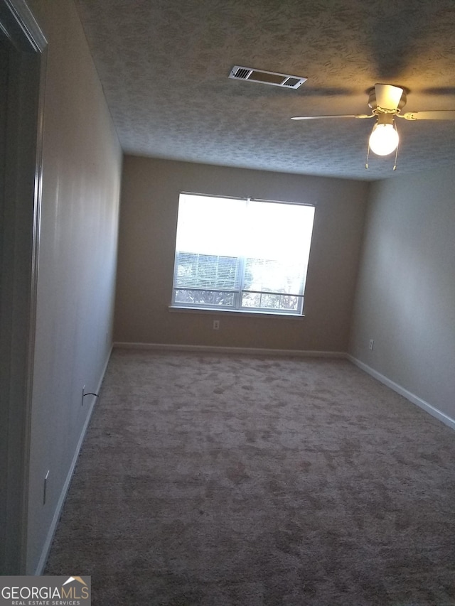 carpeted spare room with ceiling fan and a textured ceiling