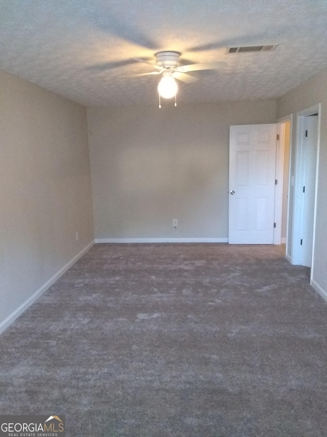 carpeted empty room with ceiling fan and a textured ceiling