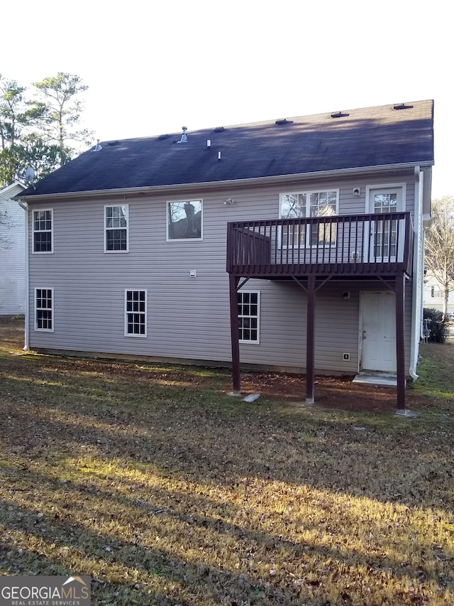 rear view of house with a yard and a deck