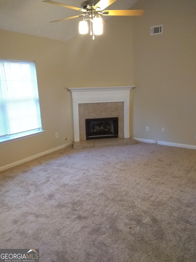 unfurnished living room with ceiling fan and carpet