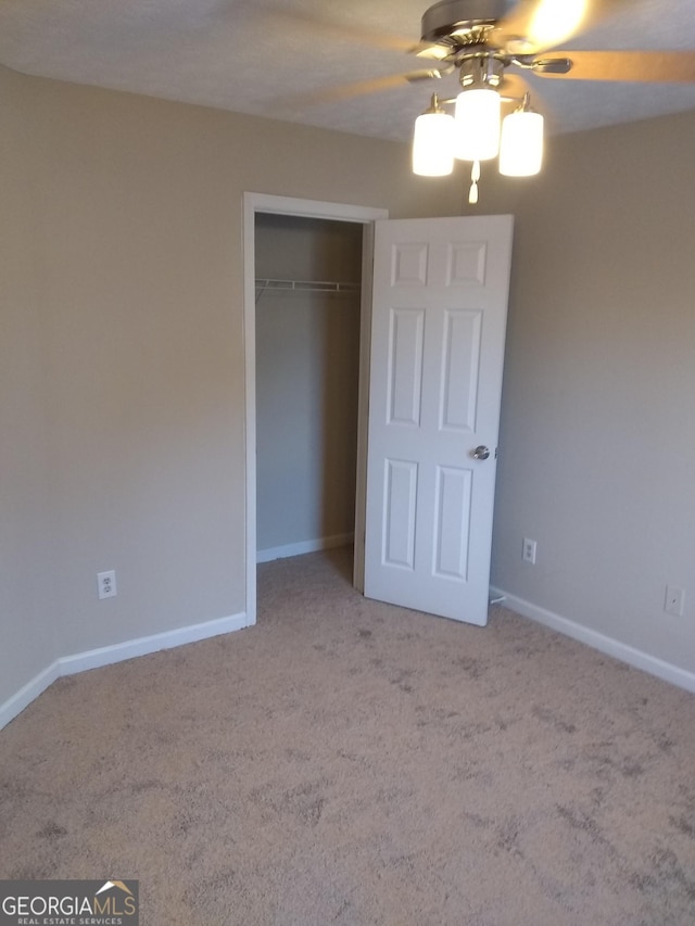 unfurnished bedroom with light carpet, ceiling fan, and a closet