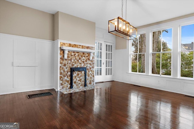 unfurnished living room featuring dark hardwood / wood-style floors and a chandelier