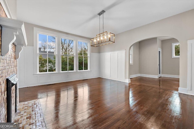 interior space featuring dark wood-type flooring, a fireplace, and a wealth of natural light