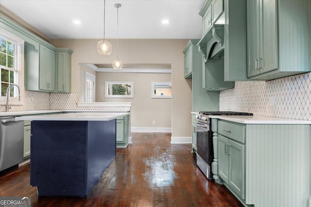 kitchen with a kitchen island, dark hardwood / wood-style floors, pendant lighting, sink, and stainless steel appliances