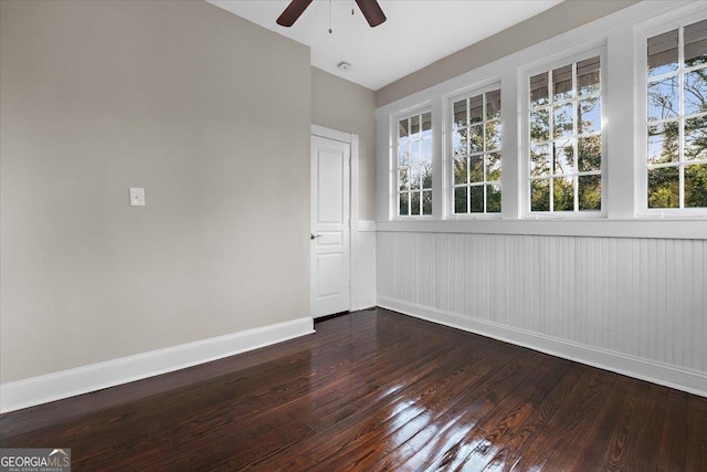 empty room with dark hardwood / wood-style floors and ceiling fan