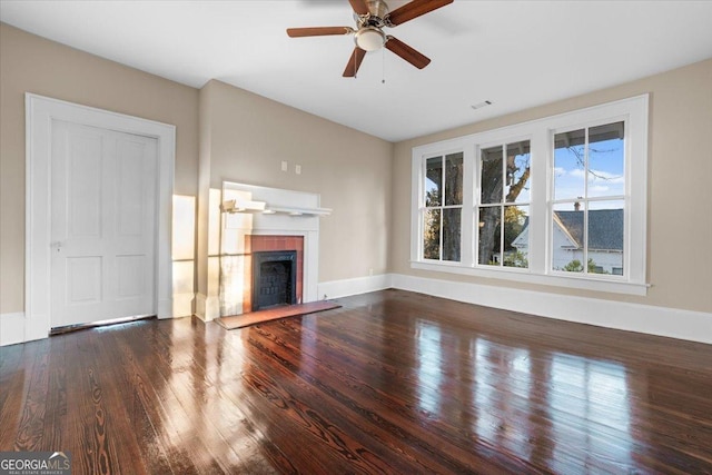 unfurnished living room featuring ceiling fan, a fireplace, and dark hardwood / wood-style floors