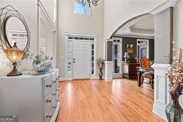 entryway featuring a towering ceiling and light hardwood / wood-style floors