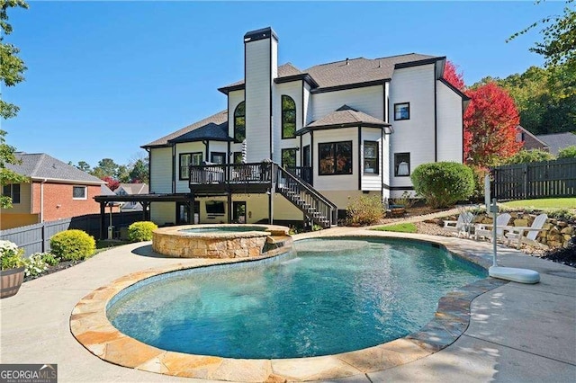 view of swimming pool featuring a wooden deck and an in ground hot tub