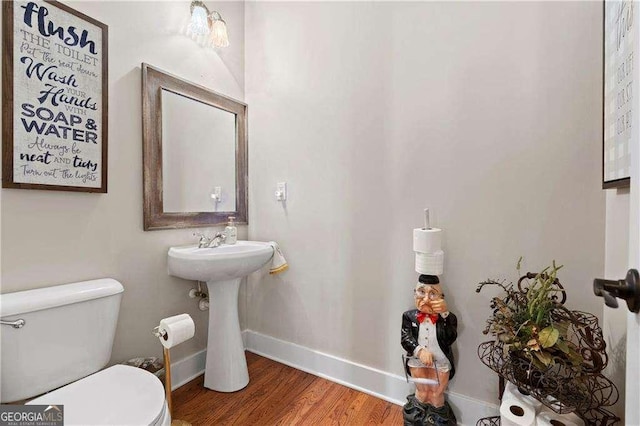 bathroom featuring hardwood / wood-style flooring and toilet