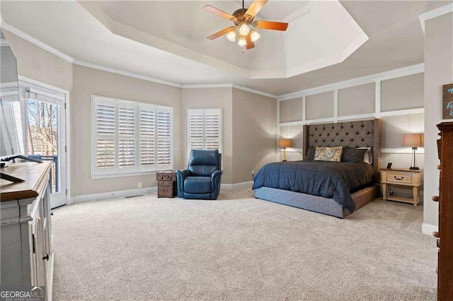 carpeted bedroom featuring ceiling fan, ornamental molding, a tray ceiling, and access to outside