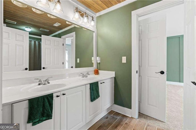 bathroom with crown molding, hardwood / wood-style floors, wooden ceiling, and vanity