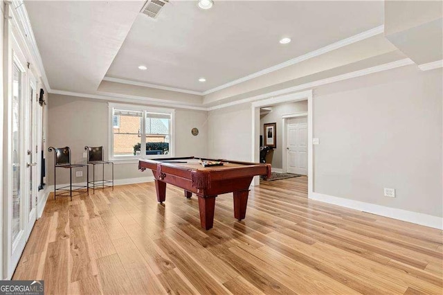 rec room with a raised ceiling, ornamental molding, light hardwood / wood-style floors, and billiards