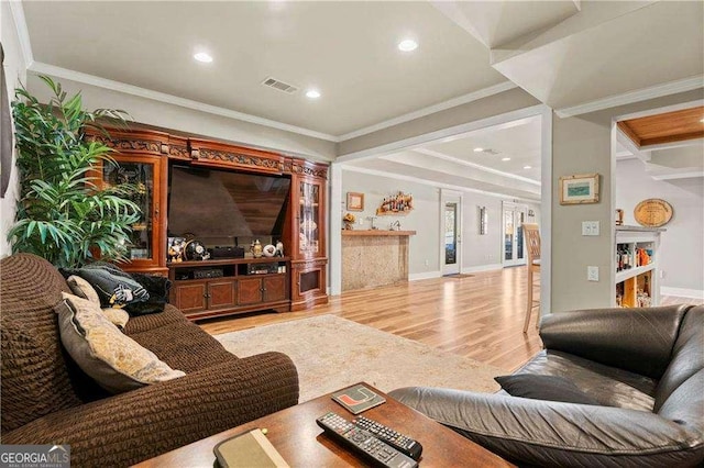 living room with crown molding and light wood-type flooring