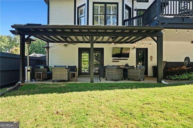 back of house featuring a balcony, outdoor lounge area, a patio area, and a lawn