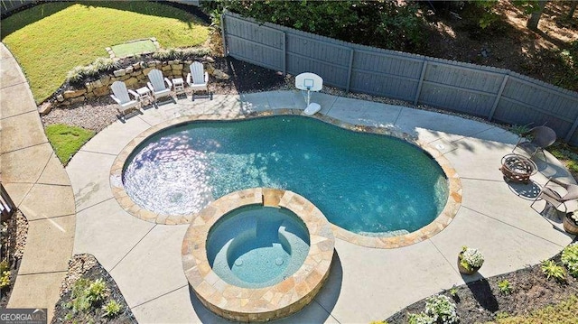 view of swimming pool featuring an in ground hot tub, an outdoor fire pit, and a patio