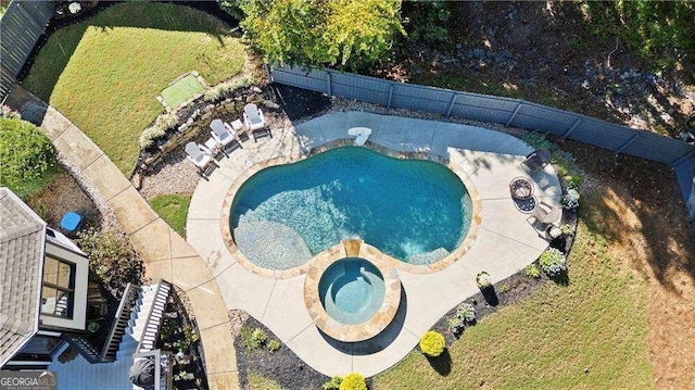 view of pool featuring a lawn and an in ground hot tub