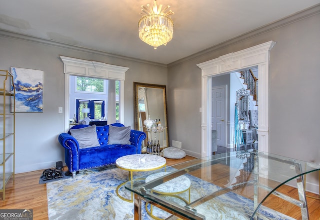 living room featuring hardwood / wood-style flooring, crown molding, an inviting chandelier, and french doors