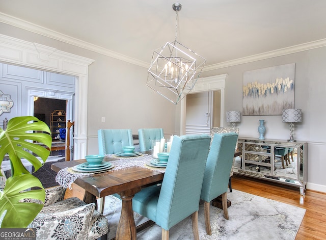 dining area featuring ornamental molding, hardwood / wood-style floors, and an inviting chandelier