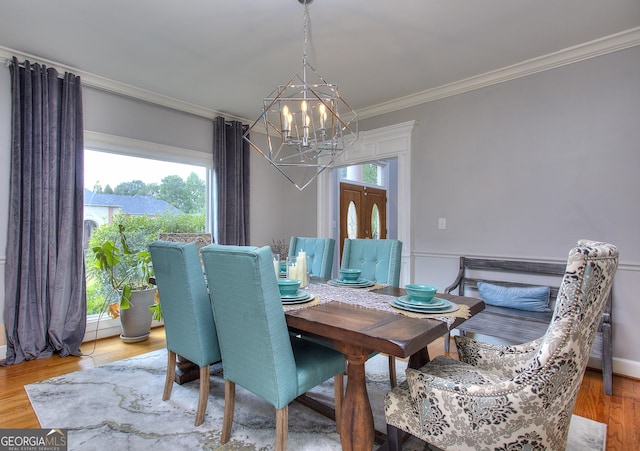 dining room with crown molding, hardwood / wood-style floors, and an inviting chandelier