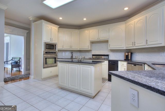 kitchen featuring light tile patterned flooring, ornamental molding, stainless steel appliances, and white cabinets