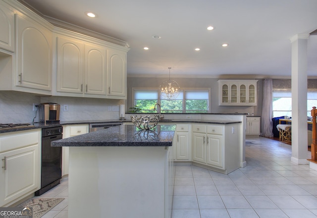 kitchen with crown molding, a center island, light tile patterned flooring, and a healthy amount of sunlight