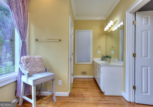 bathroom featuring ornamental molding, hardwood / wood-style floors, and vanity