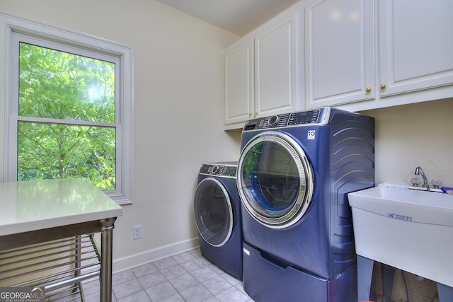 clothes washing area featuring cabinets, light tile patterned flooring, sink, and independent washer and dryer