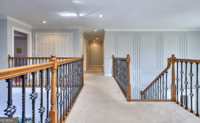 hall with crown molding and light carpet