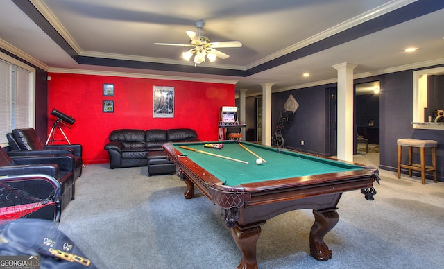 recreation room with crown molding, ceiling fan, a tray ceiling, light colored carpet, and decorative columns