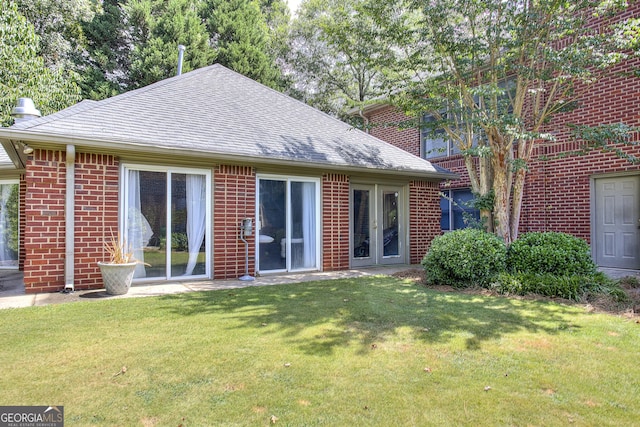 rear view of property featuring a yard and french doors