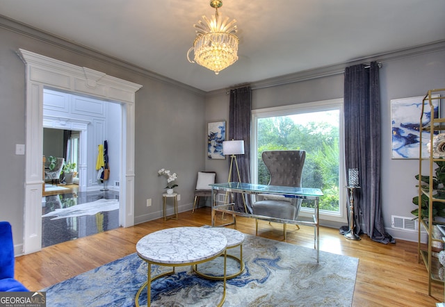 home office with an inviting chandelier, ornamental molding, and light hardwood / wood-style floors