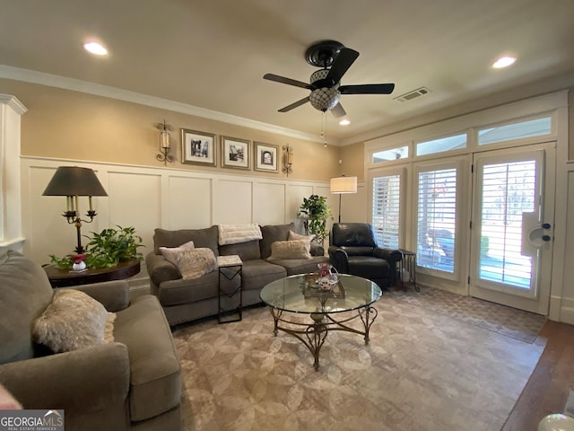 living room with ornamental molding and ceiling fan